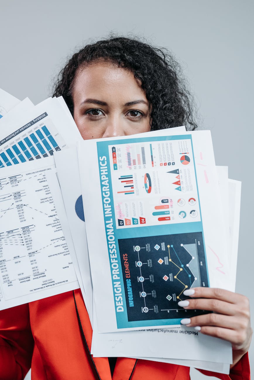 woman holding graphs and paperworks covering her face